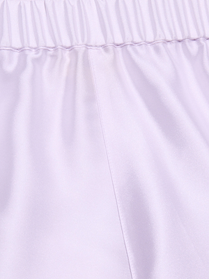Close-up of light lavender poly twill satin with a visible seam and gathered elastic waistband at the top, creating smooth, shiny folds and a soft texture—perfect for the Maela Short.