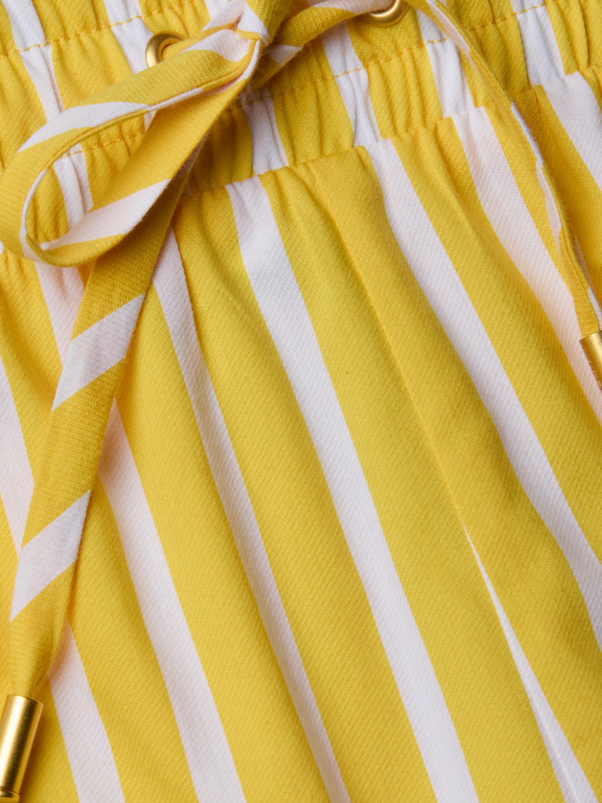 Close-up of the Royce Poplin Short, featuring yellow and white vertical stripes, a drawstring, and an elastic waistband.