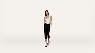 A woman in a white sleeveless top, black cropped pants, and black heels stands against a plain white background.