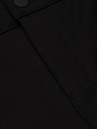 Close-up of the Amaris Pedal Pusher in black denim, highlighting a stitched seam, partial pocket detail, and a black button at the top—crafted for a body-hugging fit.