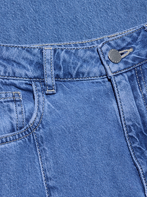 Close-up of the waistband and upper front of the Niles Wide-Leg Jean, featuring a belt loop, metal button, pocket top, and visible stitching on its all-cotton blue denim fabric.