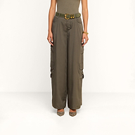 Wearing the Isolde Cargo Pant—high-waisted, wide-leg olive cargo pants made from lightweight Tencel and finished with a matching belt—a person pairs them with a sleeveless top and pointed shoes while standing against a plain white background.