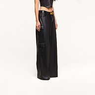A person wearing the Isolde Cargo Pant—high-waisted black wide-leg vegan leather cargo pants with utility pockets—paired with a black crop top, standing against a plain white background.