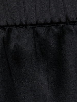Close-up of the black, slightly shiny fabric with visible stitching and gentle folds, showing the smooth, soft texture of the Joy Silk Lace Short—ideal for warm-weather style.