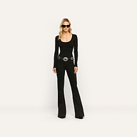 A woman wearing a black long-sleeved scoop-neck top, a silver-accented belt, and Her Story Flare Jean.