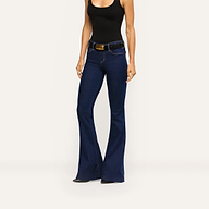 Her Story Flare Jean in dark indigo slim-cut denim worn with a black tank top and a black textured belt with a gold buckle.