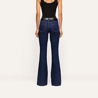 Back view of Her Story Flare Jean in slim-cut dark indigo, worn with a black tank top and a black textured belt.