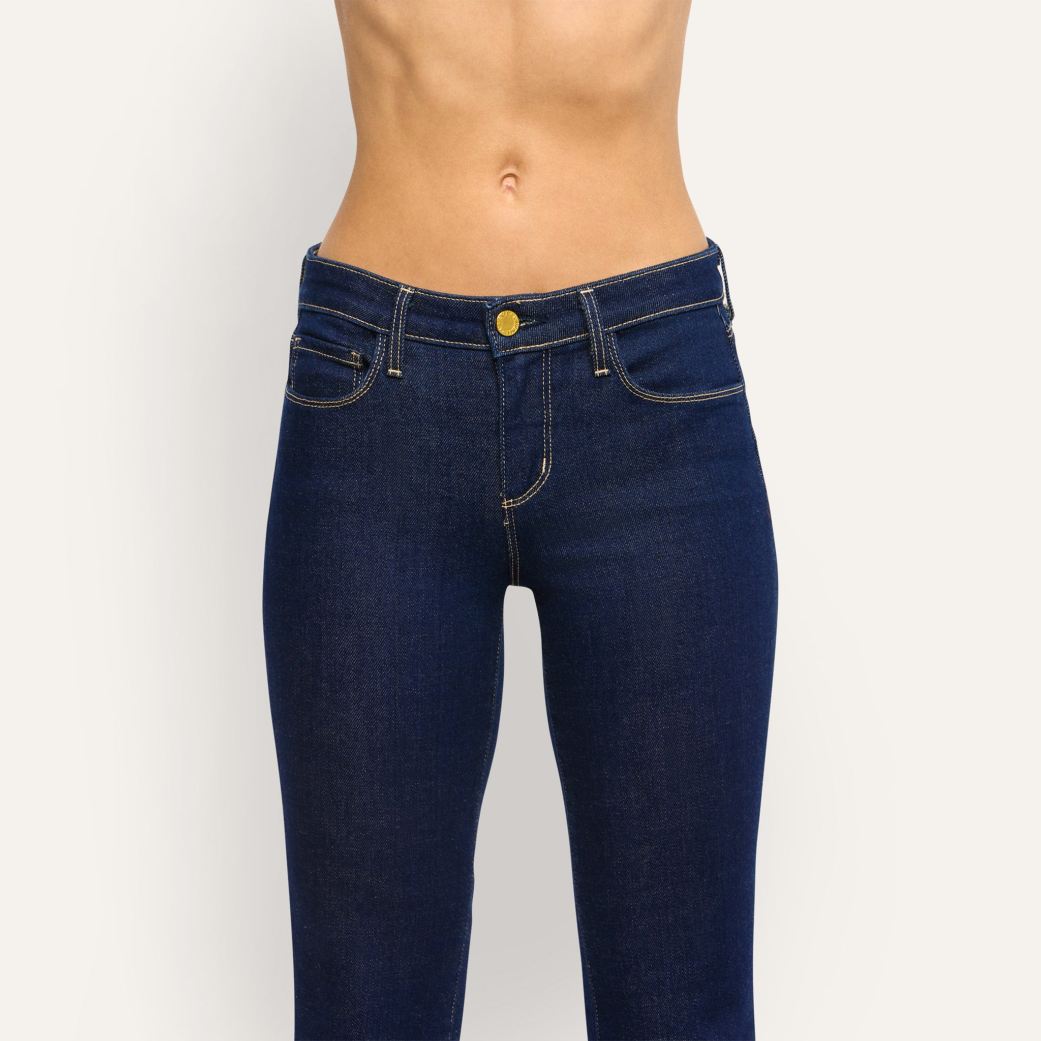 Her Story Flare Jean featuring a slim-cut, mid-rise fit, dark indigo wash, and a button fly closure.