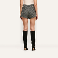 Back view of a person wearing Dionne Tweed Short high-rise wool-blend tweed shorts and black knee-high stiletto boots.