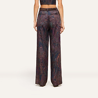 A person wearing the Livvy Trouser, a high-rise, wide-leg pant in midnight paisley, paired with a matching cropped top and shown from the back against a plain background.