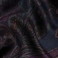 The Livvy Trouser features a dark, richly patterned fabric adorned with a midnight paisley design in shades of purple, green, and gold; the material appears slightly wrinkled and is softly illuminated.