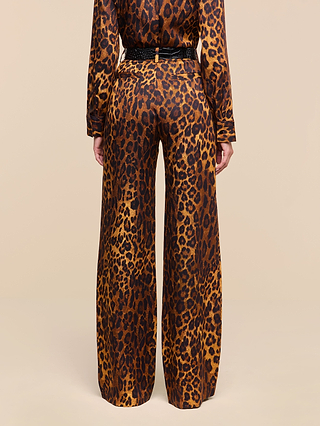 A person is shown from the back, standing in a plain beige setting, wearing the Livvy Trouser and a long-sleeve top with a tan leopard print pattern.