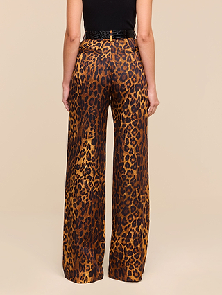 A person wearing the Livvy Trouser—high-waisted, straight-leg leopard print pants crafted from printed twill—and a black sleeveless top is shown from the back against a plain beige background.