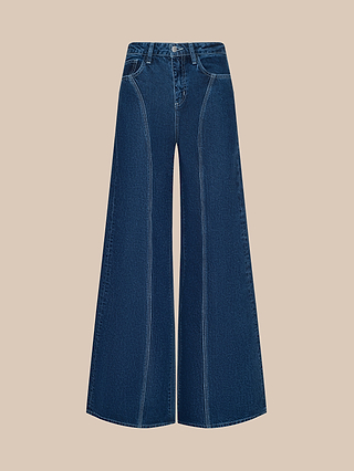 The Lestat Wide-Leg Jean is a high-waisted, all-cotton denim style with a wide-leg silhouette, prominent vertical seams, and white stitching, shown against a beige background.