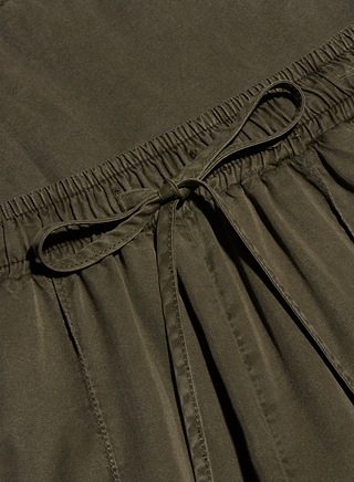 Close-up of the Chandler Cargo Pant in olive green, showcasing its elastic waistband, center tied drawstring bow, and gathered fabric detail below the waist.