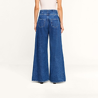 Model wearing the Sonja Corset Jean, featuring an ultra high-rise fit and wide-leg silhouette, paired with a white top. Shown from the back against a plain white background, the jeans showcase two large back pockets and a high waist.
