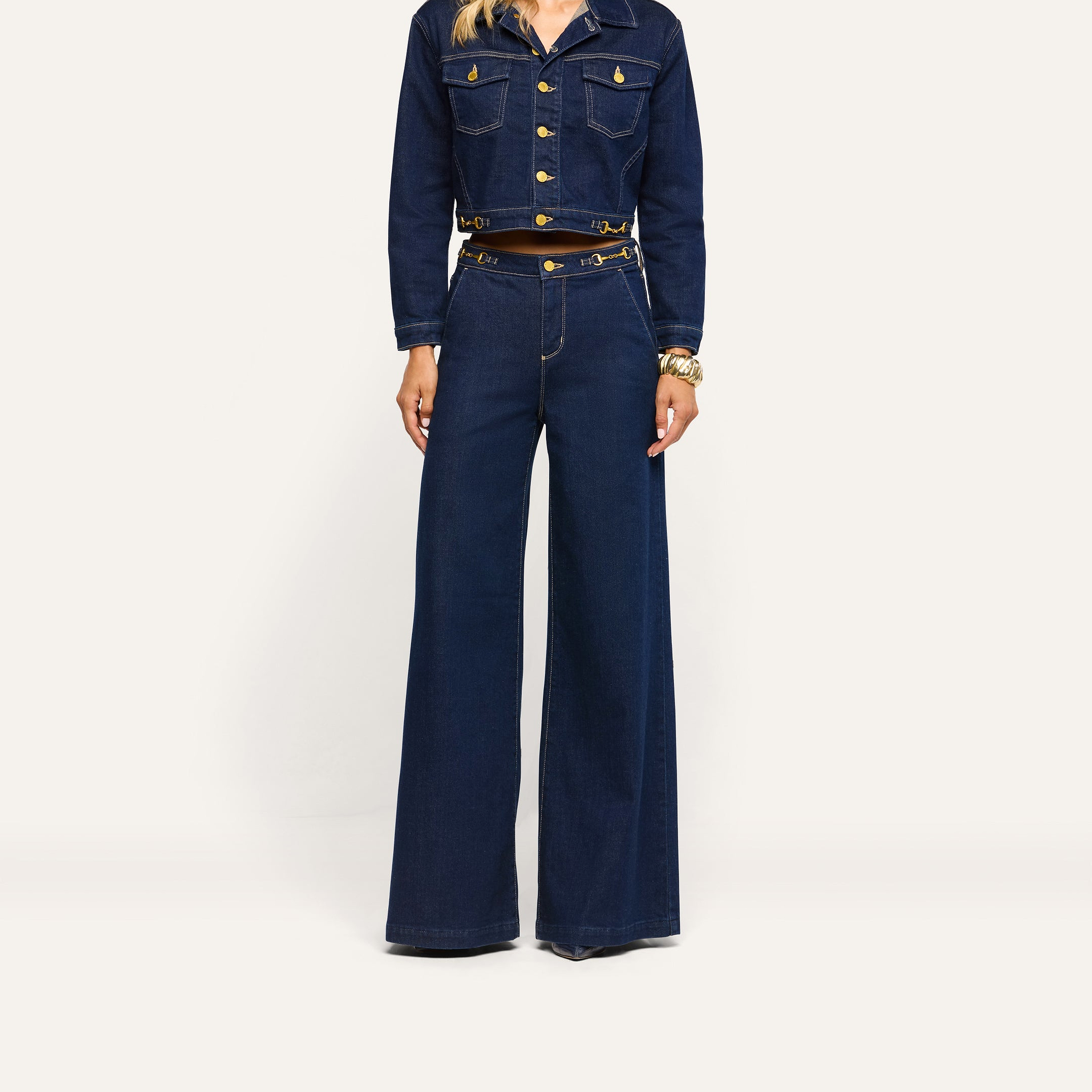 Person wearing a dark wash denim cropped jacket with gold buttons and matching Jules Wide-Leg Jean.