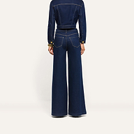 A person viewed from the back, wearing a cropped dark denim jacket and Jules Wide-Leg Jean.