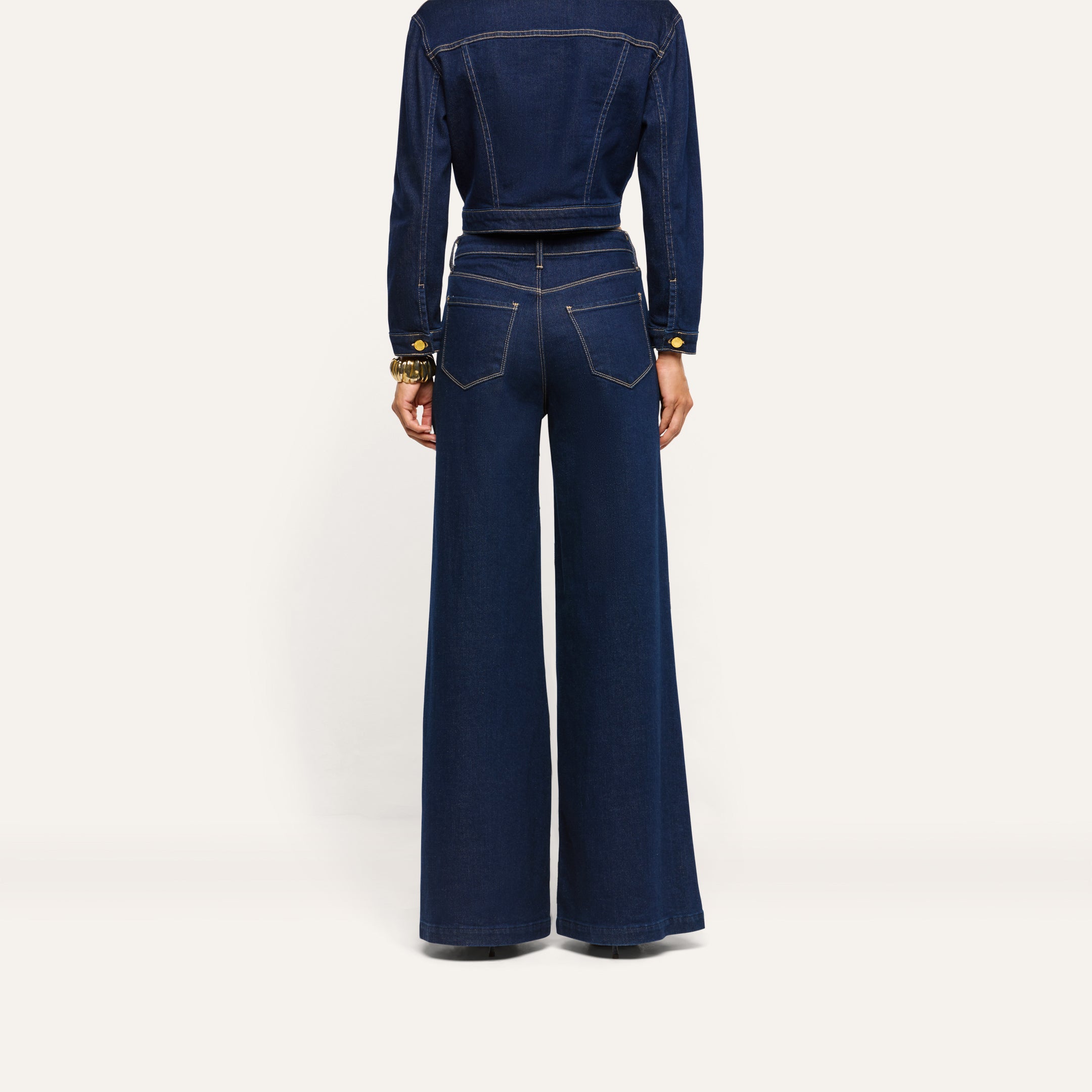 A person viewed from the back, wearing a cropped dark denim jacket and Jules Wide-Leg Jean.