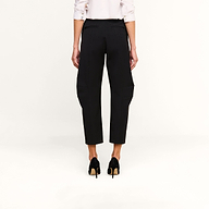 A person stands facing away against a plain white background, wearing the Colby Barrel-Leg Trouser in black, paired with a white long-sleeve shirt with rolled-up sleeves and black high-heeled shoes.