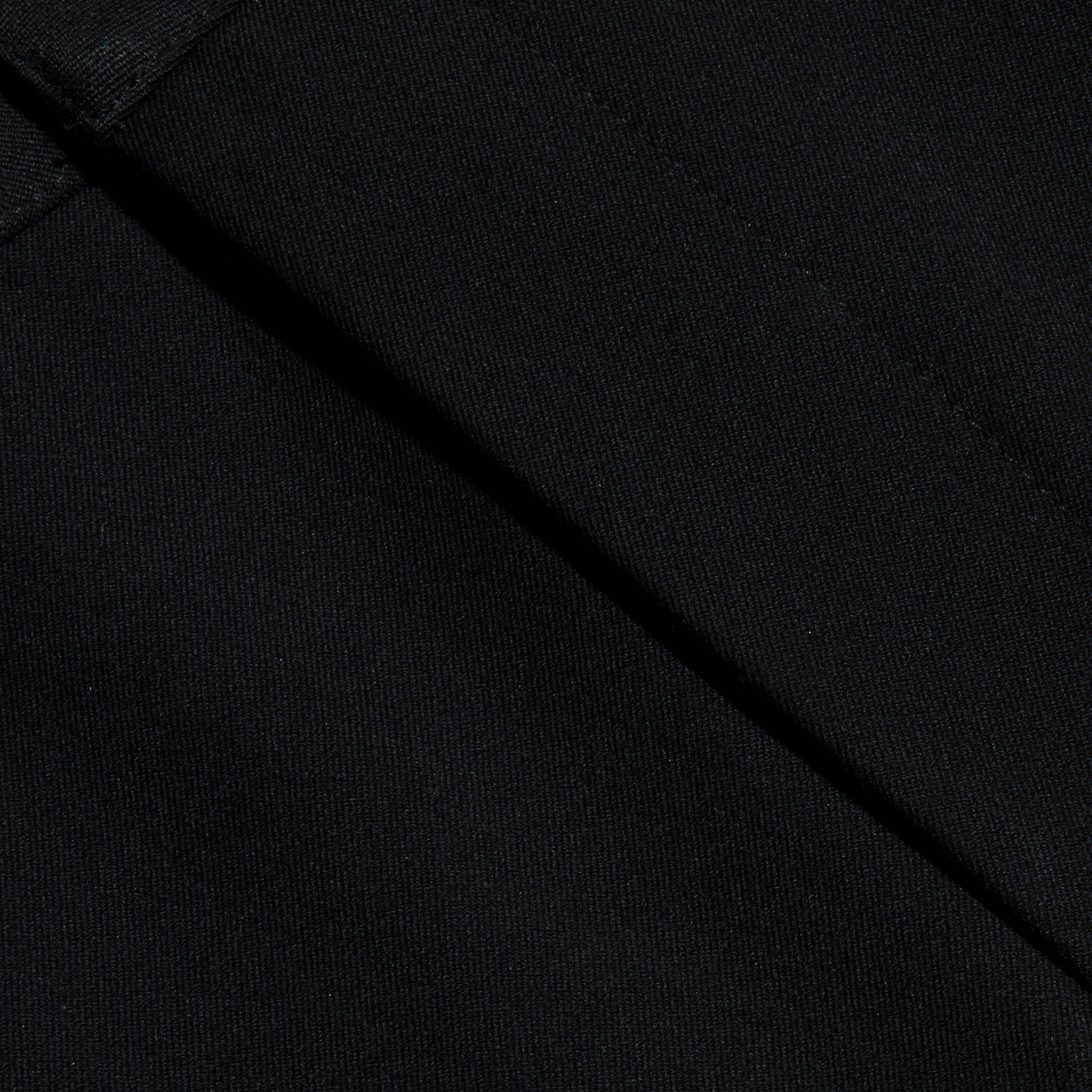 Close-up of black fabric with visible diagonal seams, showcasing the texture and stitching detail of the Colby Barrel-Leg Trouser.
