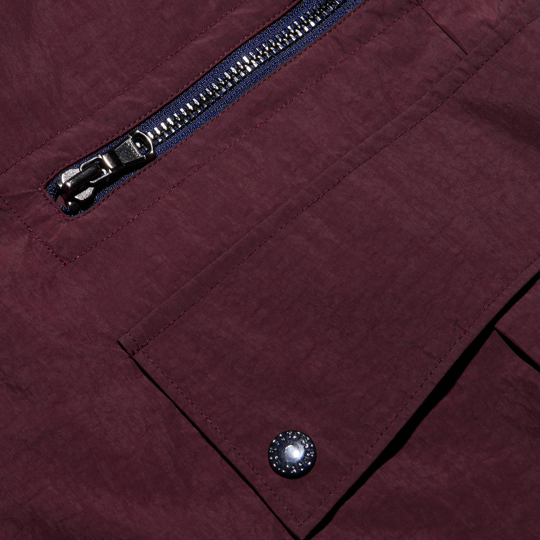 Close-up of water-repellant Monrose Nylon Joggers featuring a zippered pocket and a flap pocket secured with a metallic snap button.