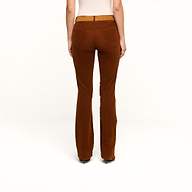 Wearing the Saffia Corduroy Pant, a person stands with their back to the camera against a plain white background, paired with a beige top.