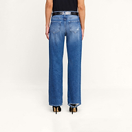 A person stands against a white background, wearing the Zelda Slouchy Straight Jean with a frayed hem, paired with a black shirt and black high-heeled shoes. The image displays a back view from waist to feet.