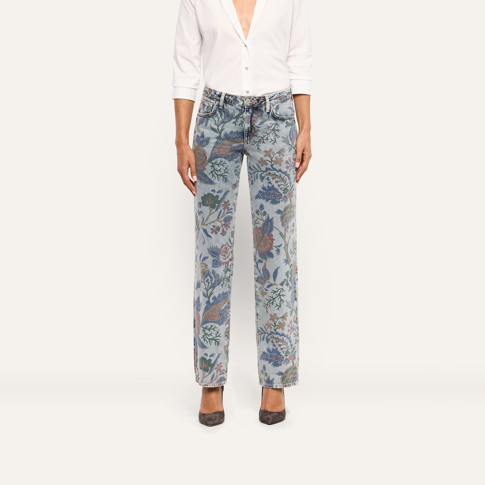 A person wearing a white button-down shirt and Gianna Stovepipe Jean featuring a vintage-style boho floral print.
