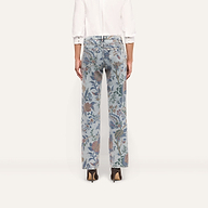 Back view of the Gianna Stovepipe Jean in a low-rise, light-wash slim fit with an all-over floral and paisley print, paired with a white button-down shirt and brown heeled boots.