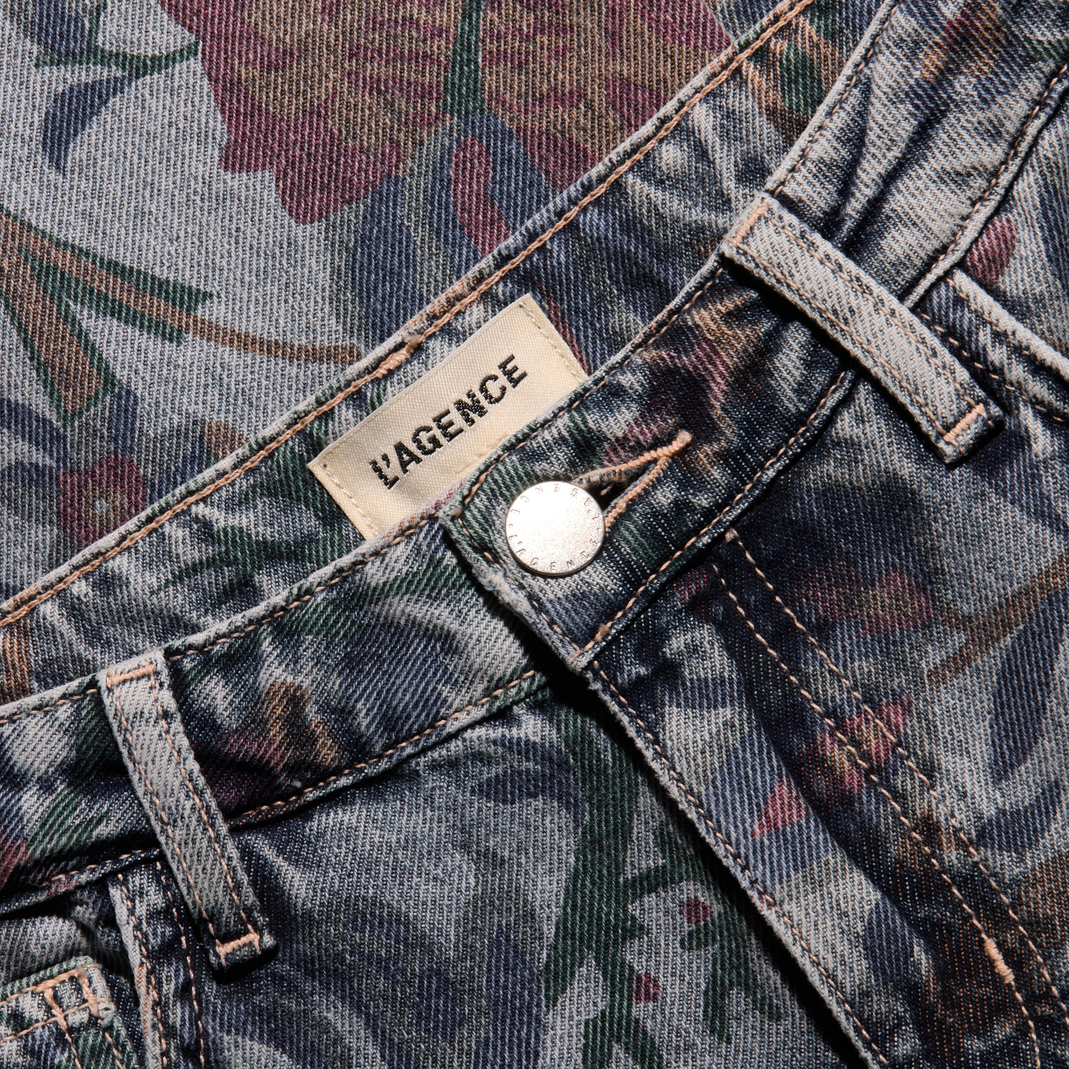 Close-up of the waistband, button, and brand label of the slim stovepipe boho-print Gianna Stovepipe Jean.