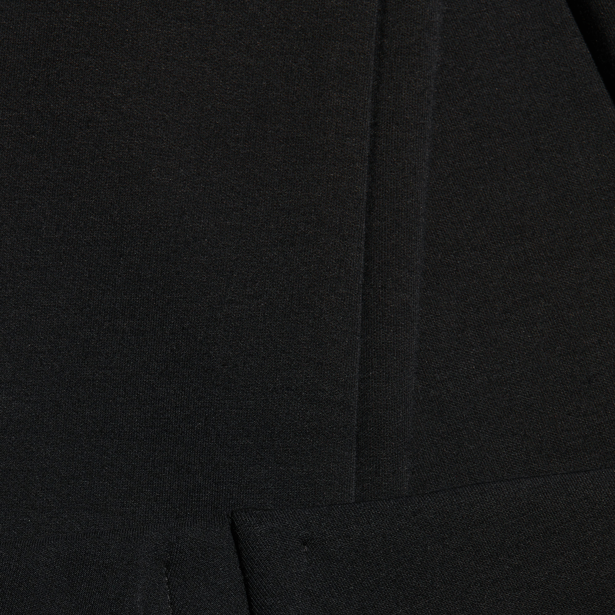 Close-up of black Enid Stirrup Legging scuba knit leggings featuring a vertical seam.