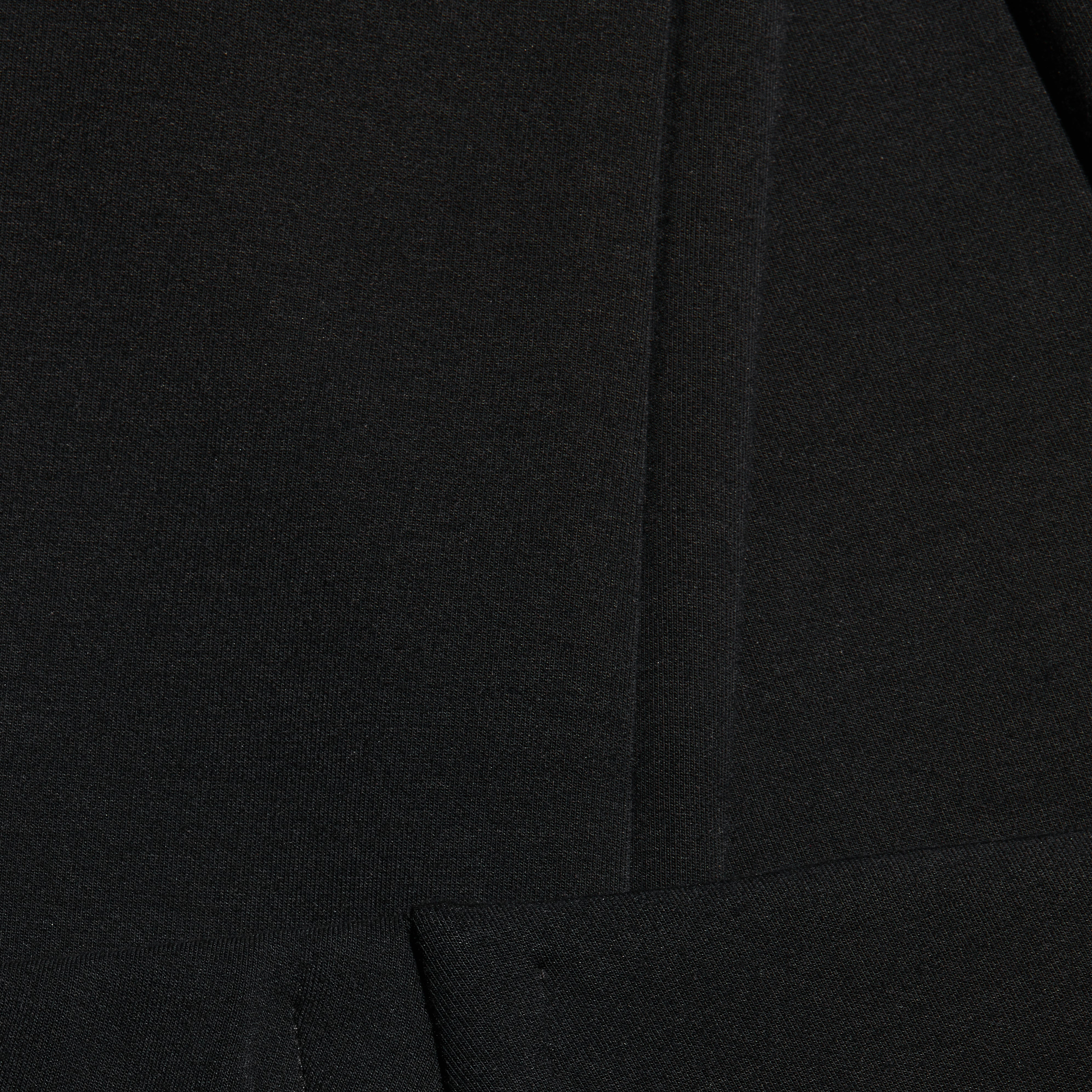 Close-up of black Enid Stirrup Legging scuba knit leggings featuring a vertical seam.