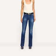 A person wearing a white tank top and Kezia Bootcut Jean low-rise stretch denim jeans with a black belt.