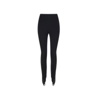 Serenity Stirrup Pant in black, high-waisted with stirrups and a slim fit, shown on a plain white background. Its minimalist design channels Paris Fashion Week style.