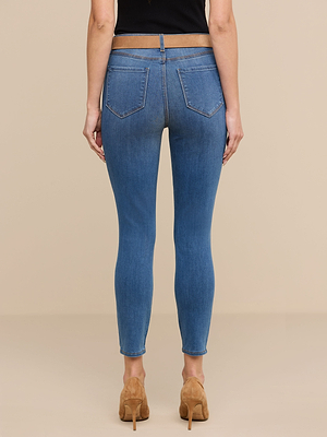 A person is shown from the back, standing against a plain beige background, wearing Margot Cropped Skinny Jeans in stretch denim and tan high-heeled shoes.