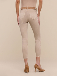 A person stands facing away against a plain white background, wearing Margot Cropped Skinny Jeans in beige stretch denim, styled with a matching belt and tan high-heeled shoes.