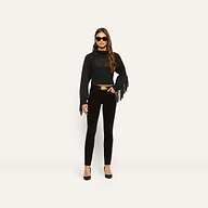 A woman wearing a black long-sleeve fringe sweater, a belt with a gold buckle, and Marguerite Corduroy Skinny Pant in black.