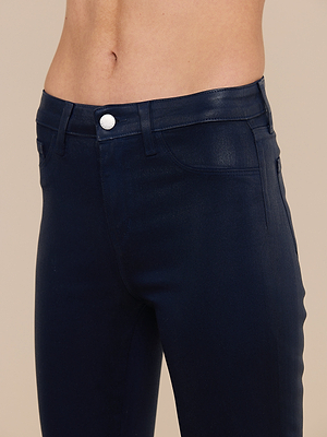 A person wearing high-waisted, dark blue Marguerite Coated Skinny Jeans with a tapered leg and silver button, shown from the waist to upper thighs against a plain background.