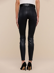 A person stands facing away from the camera, wearing the Marguerite Coated Skinny Jean in black, paired with black high-heeled shoes and a white top against a plain white background.