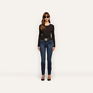 Woman wearing a black long-sleeved shirt and Marguerite Skinny Jean with a black belt and black heels.