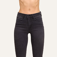 Person wearing Marguerite Skinny Jean—high-waisted black skinny jeans made from high-recovery fabric—with the front waist and abdomen shown against a plain light background.