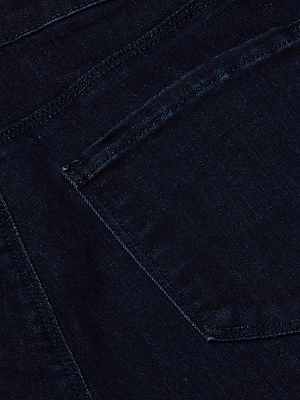 Close-up of the back pocket of the L'AGENCE Marguerite Skinny Jean in dark blue super stretch denim, showcasing detailed stitching and rich fabric texture.