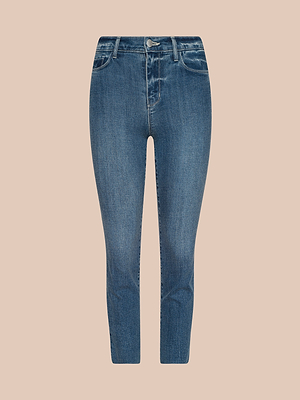 I jeans Sada Cropped Slim-Leg presentano un classico lavaggio blu, vita alta, orlo grezzo, cinque tasche e chiusura frontale con bottoni e cerniera, come mostrato su uno sfondo beige a tinta unita.