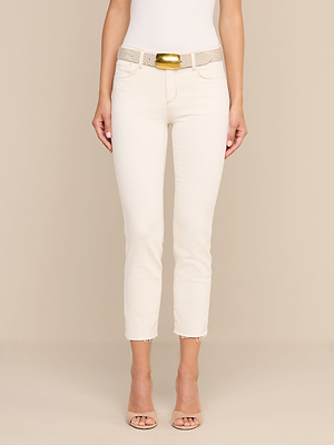 Eine Person, die eine „Sada Slim-Leg Cropped Jean“ aus hochwertigem Stretch-Denim, ein weißes, figurbetontes Oberteil, einen beigen Gürtel mit einer großen goldenen Schnalle sowie beige Pumps mit offener Spitze trägt, steht vor einem schlichten beigen Hintergrund.
