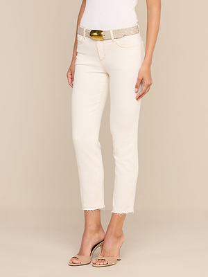 Vor einem beigen Hintergrund steht eine Frau, die die „Sada Slim-Leg Cropped Jean“ aus cremefarbenem Premium-Stretch-Denim trägt, kombiniert mit einem weißen Oberteil, einem beigen, strukturierten Gürtel mit goldener Schnalle und hautfarbenen Peep-Toe-Pumps.