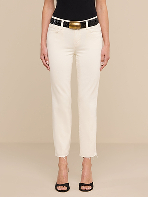 A person wearing Sada Slim-Leg Cropped Jeans, a black tank top, a black and gold belt, and black open-toe heels stands against a beige background.