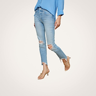 A person wearing a blue shirt, the High Line Distressed Skinny Jean with frayed hems and ripped knees, and beige heeled sandals stands against a plain white background.