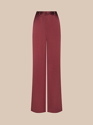 The Pilar Silk Wide-Leg Pant features a high-waisted, wide-leg silhouette in a rich maroon shade, crafted from luxurious silk pant fabric and displayed against a plain light beige background.