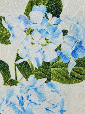 Close-up of L'AGENCE Sale Pilar Satin Wide-Leg Pant, showcasing a light blue and green hydrangea jacquard print with swirling embroidered texture on a white background.